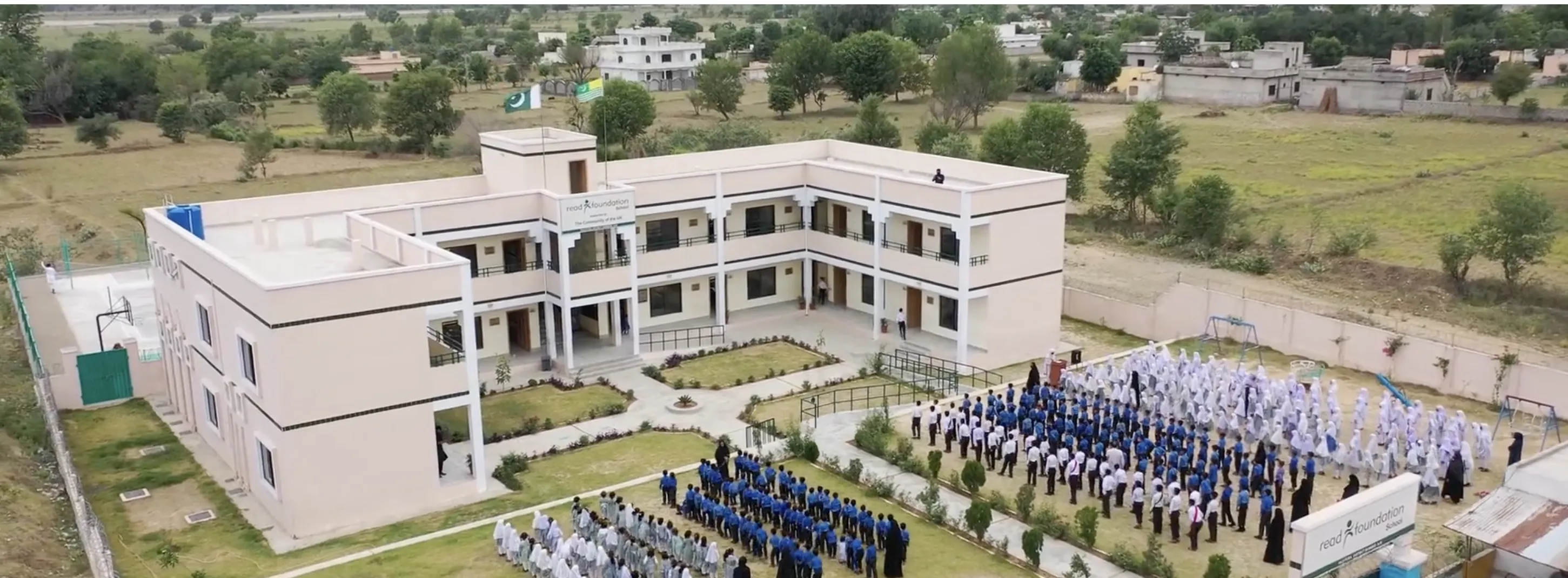 Aerial view of a completed READ Foundation school with students assembled in the courtyard