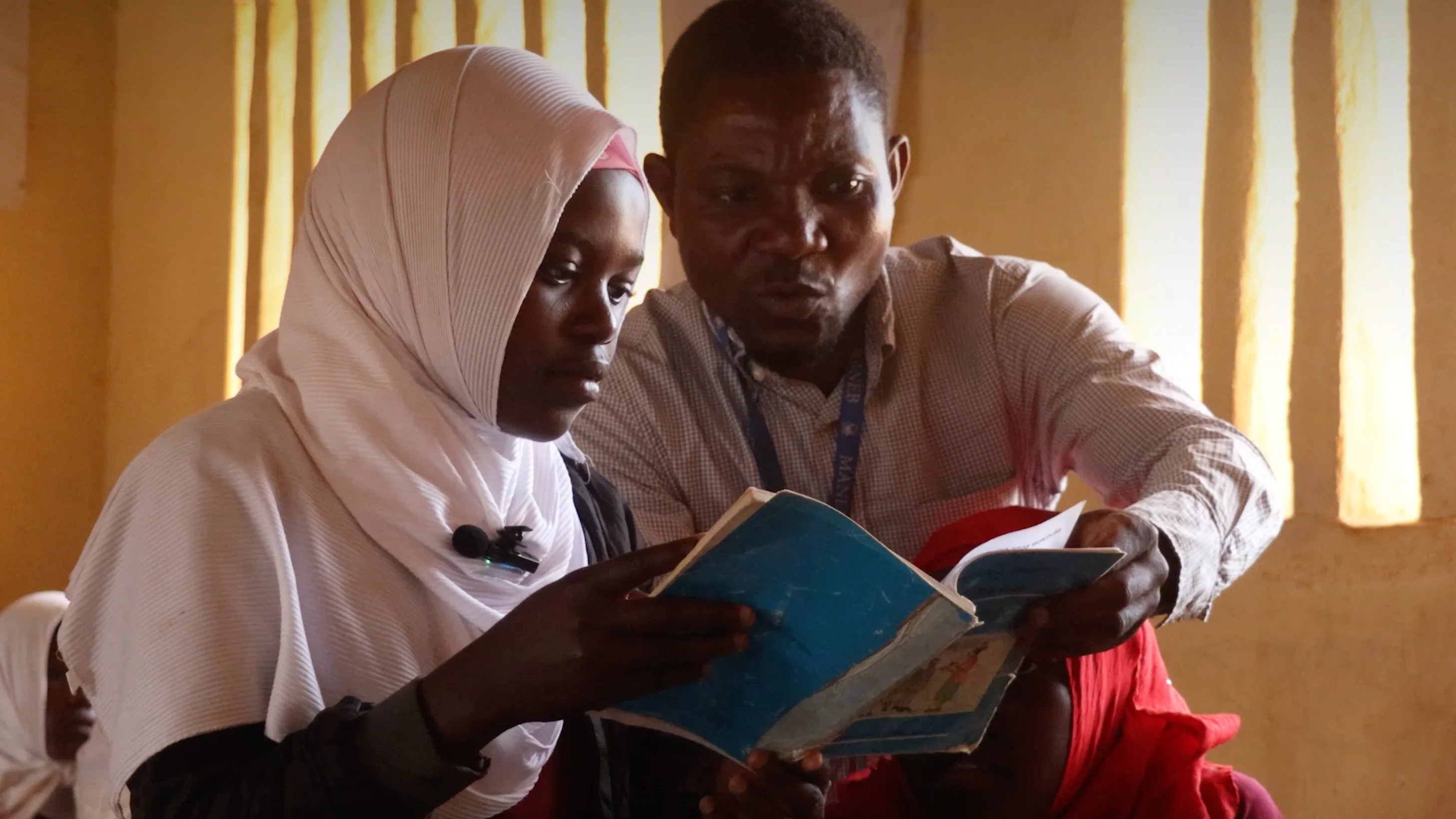 Teacher reading with a student in Malawi